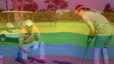 Kadın golf sopasını yeşil üzerine sallarken erkek diz çöküp golf topunu inceliyor. Profesyonel, boş zaman, açık hava, performans, spor, zarafet, yaşam tarzı