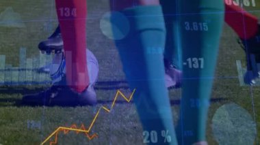 Sahada duran erkek sporcular, futbol topu ve kramponların üzerinde çizelgelerle spor analizlerini gösteriyorlar. Atletizm, performans, veri görselleştirme, takım çalışması, spor giyim, yarışma, açık hava