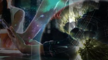 Çalışma alanında iş birliği yapan iş arkadaşları akıllı telefon, dizüstü bilgisayar ve küresel kaplama gösteriyor. İşbirliği, teknoloji, yenilik, bağlantı, takım çalışması, modern, dijital