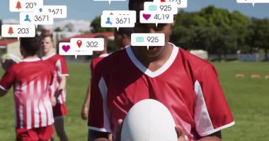 Spor takımı topu çimlerin üzerinde tutuyor, dijital pazarlama için yüzen medya metrik simgelerini gösteriyor. Sporcular, takım çalışması, açık hava, spor, rekabet, gençlik, spor