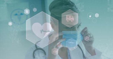 Kadın doktor klinikteki maske kayışlarını ayarlıyor, yüzen altıgen medikal ikonlar var. Tıbbi, sağlık, profesyonel, teşhis, hijyen, acil durum, tıbbi ekipman