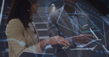 İş arkadaşları ellerinde telefon ve dizüstü bilgisayarla iş birliği yaparak iş verilerini üst üste koyuyorlar. Teknoloji, takım çalışması, yenilik, fütürizm, şirket, dijital, iş