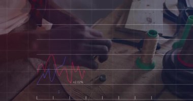 Sanatçının elleri atölyedeki deri kayışlara toka takıyor ve animasyon finans grafiklerini gösteriyor. Zanaatkârlık, marangozluk, marangozluk, deri işçiliği, el yapımı, zanaat, atölye