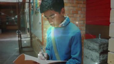 Erkek öğrenci koridorda pencereli yazı yazıyor, eğitim için yüzen kalem simgeleri sergiliyor. Gençlik, ilham, yaratıcılık, modern, mimari, öğrenme, konsantrasyon