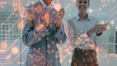 Erkek yönetici ve bayan meslektaşı ofiste alkışlıyor, devre grafikleri teknoloji temasını gösteriyor. Şirket, yenilik, fütüristik, profesyonel, işbirliği, başarı, modern