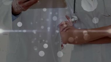 Tıp kliniğinde tableti inceleyen laboratuvar önlüğü giyen iki doktor dijital bokeh örtüsü sergiliyor. Profesyonel, sağlık, teknoloji, işbirliği, yenilik, klinik, tanı