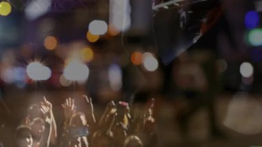 Gece konserinde sahne ışıkları altında müzik notaları eşliğinde kalabalığı kendine çeken sanatçı. Livemusiç, konser, festival, performans, sahne, seyirci, canlılık