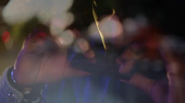 Gece vakti şehir teknolojisi sahnesinde, yüzen bokeh veri parçacıkları ile güneş gözlüğünü ayarlayan adam. Moda, aksesuarlar, şehir, gece hayatı, şık, soyut, canlı