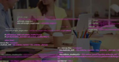 Geliştirici ikili masadaki yazılımda yüzen kod parçalarını gösteren dizüstü bilgisayarla işbirliği yapıyor. İşbirliği, takım çalışması, yenilik, teknoloji, modern, üretkenlik, başlangıç