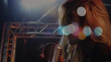 Kadın şarkıcı konser sahnesinde, animasyon bokeh ışık noktalarıyla müzik kavrayışlarını yönlendiriyor. Drama, performans, eğlence, heyecan, tutku, gece hayatı, sahne