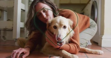 Çamaşırhanede köpeğe sarılan, parlayan neon bir kalple evcil hayvan terapisi yapan bir kadın. Duygusal, samimi, yaşam tarzı, samimiyet, arkadaşlık, evcil, hayat dolu.