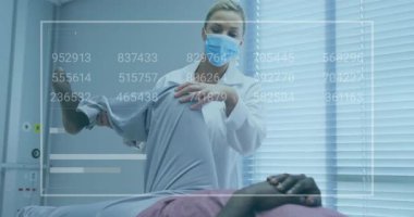 Kadın doktor, erkek hasta dizini klinikte muayene ediyor. Yüzen numaralar ve bar çizelgeleri var. Tıbbi, sağlık, teknoloji, tanı, klinik, yenilikçi, profesyonel