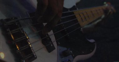 Animasyon EQ çubukları ve müzik verileriyle, karamsar sahne ışıkları altında metal teller koparan basçı. Müzisyen, enstrüman, performans, karamsar, kontrast, yansıma, sanatçılık
