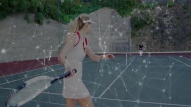 Kadın oyuncu tenis kortunda salıncak hazırlıyor. Teknoloji eğitimi için parlayan ağ örtüsünü sunuyor. Atletik, rekabetçilik, dijital, modern, açık hava, enerji, eğlence