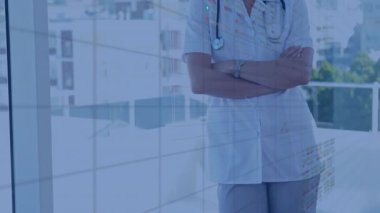 Pencerenin yanında duran beyaz önlüklü kadın doktor sağlık teknisyenleri ve stok grafikleri gösteriyor. Tıbbi, sağlık, teknoloji, profesyonel, kentsel, yenilik, danışmanlık