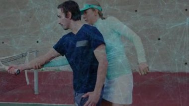 Erkek koç, tenis kortunda hareketli ağ ve spor koçluğu verileriyle sallanan öğrencilere rehberlik ediyor. Atletik, öğretim, eğitim, açık hava, enerji, spor, hassasiyet