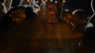 Gece vakti sokakta duran kovboy şapkalı üç arkadaş yüzen pazarlama çizelgesi gösteriyor. Siluet, gece hayatı, şehir, moda, yoldaşlık, macera, bağımsızlık