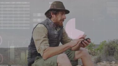 Kayalık yamaçta akıllı telefonları dinleyen erkek yürüyüşçü animasyon aletleri ve teknik çizelgeler sergiliyor. Macera, keşif, teknoloji, analiz, iletişim, yaban hayat, yenilik