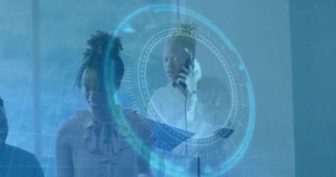 Ekip teknoloji ofisinde işbirliği yapıyor, mavi HUD verilerini üst üste koyuyor ve elinde akıllı telefon tutan adam var. Teknoloji, yenilik, dijital, fütüristik, iletişim, takım çalışması, veri