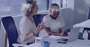 Modern ofis masasında iş stratejisini tartışan iki kadın ve hareketli veri tabloları. İşbirliği, takım çalışması, iletişim, profesyonel, girişim, beyin fırtınası, üretkenlik