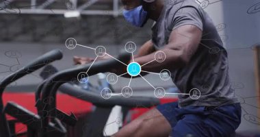 Modern jimnastik salonunda kardiyo makinesine yaslanmış bir adam. Fitness, teknoloji, spor, sağlık, atletik, yenilik, sağlık