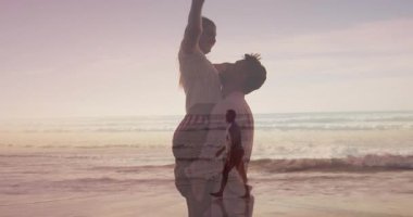 Hamile bir kadın plaj günbatımında partnerleri tarafından kaldırılıyor ve sağlık çizelgesi üst üste geliyor. Romantik, kutlama, mutluluk, dinginlik, yaşam tarzı, tatil, aşk