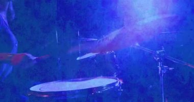 Canlı müzik notaları ve neon barlarla loş sahnede davul çalan bayan davulcu. Müzisyen, ritim, performans, atmosfer, canlı, eğlence, gece hayatı
