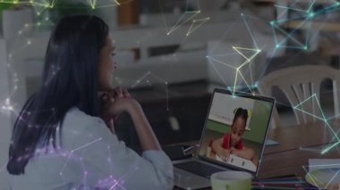 Kadın çocuğa internetten bilgisayar dersi veriyor, ağ hatlarını örtüyor ve eğitimde parlayan düğümler atıyor. Teknoloji, öğrenme, iletişim, dijital, eğitim, ev, işbirliği