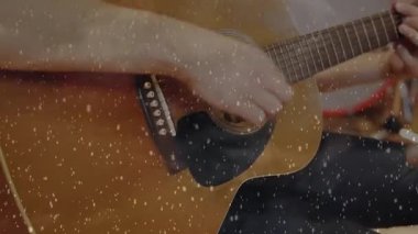 Erkek gitarist, bateristin yanında akustik gitar tıngırdatıyor. Müzik stüdyosunda film tahılları sergiliyor. Müzik, işbirliği, vintage, performans, ses, yaratıcılık, stüdyo