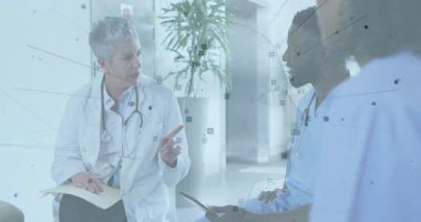 Kıdemli doktor ve meslektaşı hastane salonunda verileri tartışıyor, animasyon sağlık çizelgeleri gösteriyor. Tıbbi ekip, işbirliği, profesyonel, sağlık, danışma, modern tasarım, hastane ortamı