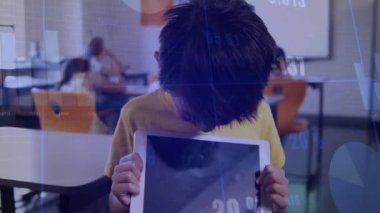 Sınıfta elinde tablet tutan çocuk, eğitim teknolojisini gösteren süzülen bar tabloları sergiliyor. Öğrenme, eğitim, teknoloji, çocuklar, sınıf, dijital, etkileşimli