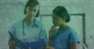 Kıdemli doktor, kıdemsiz hemşireye ağ düğümü grafikleriyle birlikte panoyu incelemesi için rehberlik ediyor. Sağlık, işbirliği, akıl hocalığı, tıbbi, profesyonellik, yenilik, teknoloji