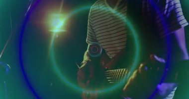 Şarkıcı karanlık sahnede mikrofona performans sergiliyor, neon ışıklarını çevreleyen müzik teknolojisini canlandırıyor. Performans, eğlence, gece hayatı, gösteri, dinamik, canlı, akustik