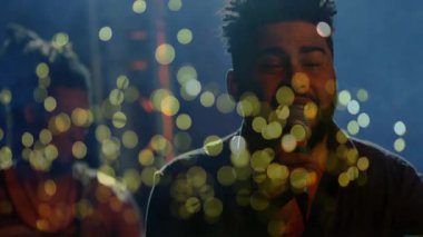 Grup arkadaşı olan erkek şarkıcı sahnede şarkı söylüyor, mikrofonu tutuyor ve animasyon ışıkları yakıyor. Performans, vokaller, eğlence, sahne, konser, müzik, ambians