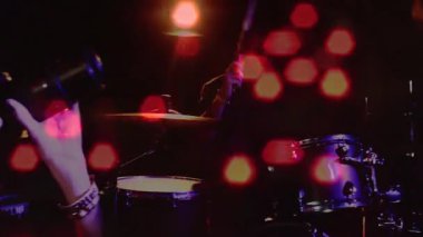 Gitarist akustik gitar çalıyor, baterist kırmızı Bokeh animasyonlarıyla oynuyor. Sahne, canlı performans, müzikal, canlı, akustik, grup, eğlence