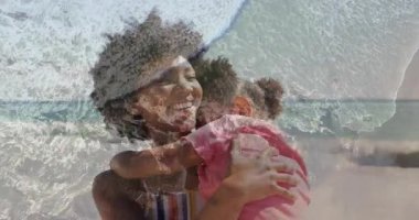 Plajda çocuğa sarılan bir kadın. Animasyon kalp ikonları ve çizelgesiyle sağlık verilerini gösteriyor. Aile, şefkat, bağlantı, sağlık, açık hava, hayat dolu, dingin