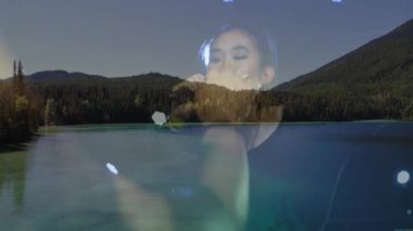 Kadın şarkıcı sahnede mikrofon kullanarak şarkı söylüyor. Dağ Gölü 'nün üzerinde mavi spot ışıklarını gösteriyor. Doğal manzara, canlı performans, sanatsal kompozisyon, canlılık, akustik, açık hava macerası, multimedya