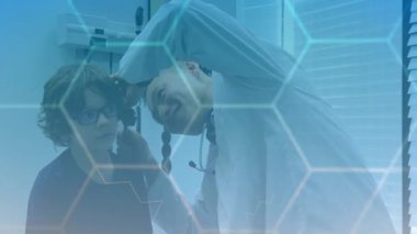 Erkek doktor, tıbbi klinikteki hastayla otoskop kullanıyor. Animasyon kulak grafiği ve veri tablosu var. Sağlık, pediatri, muayene, tıbbi, teşhis, profesyonel, danışma