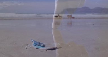 Orta yaşlı bir adam kıyı şeridinde ıslak kuma basıyor ve yüz maskesi üzerinde HUD taramaları yapıyor. Plaj, sağlık, teknoloji, holografik, çevre, kirlilik, analiz