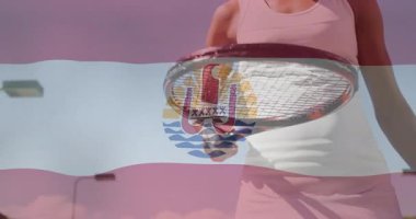 Tenis raketini kavrayan ve dengeleyici bir kadın, spor bayrağı kaplaması ve güneş amblemi ile. Spor, rekabetçi, enerjik, enerjik, açık hava, spor, atletizm