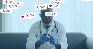 Doktor kanepede steteskop eldiveni tekniği gösteriyor, yüzen sosyal medya ölçümleri var. Tıbbi, sağlık, dijital, modern, klinisyen, teknoloji, profesyonel