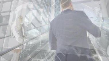 İş arkadaşları atriyumda yürüyen merdivene tırmanıyor, akıllı telefon verileri ve yüzen grafikler gösteriyorlar. Şirket, teknoloji, modern, ağ, profesyonel, yenilik, çalışma alanı