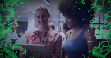 Ofiste tablet üzerinde işbirliği yapan iki kadın, verileri birbirine bağlayan teknoloji ağını gösteriyor. İşbirliği, yenilik, bağlantı, dijital, takım çalışması, modern, toplumsal