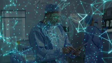 Tıbbi ameliyathanede tablet kullanan erkek klinisyen holografik veri çizgileri ve küreyi yansıtıyor. Tıbbi, teknoloji, fütüristik, işbirliği, sağlık, yenilik, kısır