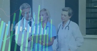 Hastane koridorundaki tablet verilerini inceleyen sağlık ekibi dikey çizgi çizelgelerini gösteriyor. Tıbbi, takım çalışması, veri görselleştirme, profesyonel, dijital, klinik, teşhis