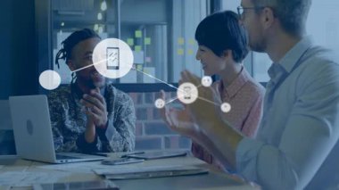 İş arkadaşları toplantı masasında oturmuş akıllı telefon müzik ikonlarının animasyon ağını gösteriyorlar. İşbirliği, takım çalışması, yenilik, yaratıcılık, dijital, bağlantı, modern