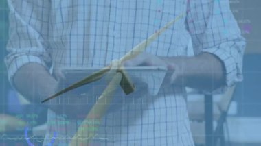 Mühendis teknoloji ofisinde tablet verilerini sunuyor, rüzgar türbini modelini hareketli grafiklerle örtüyor. Yenilenebilir, yenilikçi, takım çalışması, teknoloji, sürdürülebilirlik, analiz, modern