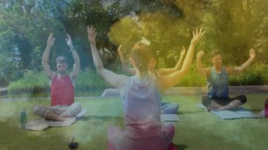 Minderler üzerinde grup yoga çalışması, yüzen sağlık grafikleri ve kalp ikonu animasyonları. Açık hava meditasyonu, farkındalık, sağIık, dinginlik, doğal bağlantı, rahatlama, bütünsel