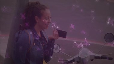 Şehir kaldırımında akıllı telefona konuşan bir kadın, mor parçacıklarla teknolojinin altını çiziyor. Kentsel, yaşam tarzı, dijital, canlı, çağdaş, hareketlilik, yenilik