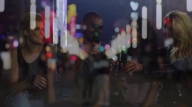 Müzik mekanında yeşil şişe tokuşturup hareketli mikrofon tribünleri ve bokeh gösteren beş arkadaş grubu. Kutlama, gece hayatı, yoldaşlık, canlı, sosyal, şenlikli, multimedya